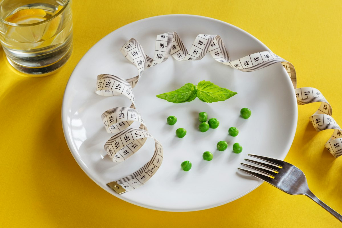 Femme préparant une assiette équilibrée et colorée dans sa cuisine